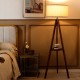 Tripod floor lamp with brown rubber wood base and flaxen shade, perfect for modern home decor and even light diffusion.