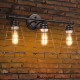 Three-light vanity lamp with metal wire cage in oil rubbed bronze finish, ideal for vintage industrial decor in.