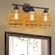 Three-light vanity lamp with metal wire cage in oil rubbed bronze finish, ideal for vintage-style bathroom lighting.