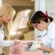 Manicure nail table in pink with built-in dust collector and bendable USB LED lamp for convenient nail care.