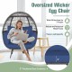 Oversized rattan egg lounge chair with navy cushions, sturdy metal frame, and cozy design for indoor or outdoor use.