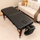 Folding massage table in black with height-adjustable beech wood frame, featuring memory foam for ultimate comfort.
