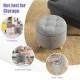 Round gray upholstered ottoman with solid rubber feet, offering storage and versatile use as a footstool or side table.