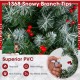 Close-up of snowy branch tips on a 7.5 ft hinged Christmas tree with fireproof PVC, featuring red berries and LED.