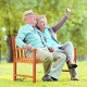 Two people enjoying a selfie on a 2-seat patio wood bench made of premium eucalyptus, perfect for outdoor relaxation.