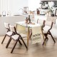 Wooden folding dining chairs with padded linen seats, compact design for space-saving in living room or cafe settings.