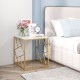 Square end table with a gold geometric frame and tempered glass top, perfect for stylish bedroom decor.