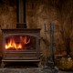 5-piece black fireplace tool set with ergonomic handles, including tongs, brush, shovel, and poker, beside a cozy fire.