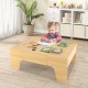 Child playing at a wooden train set table, featuring a reversible tabletop and spacious drawer for accessories.