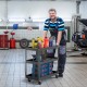 3-tier black metal utility cart with flat handle and lockable wheels, ideal for storing tools in garages or workshops.