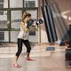Hanging punching bag set with gloves, showcasing a user training indoors for boxing and kickboxing workouts.