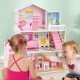 Kids playing with the pink wooden dollhouse featuring 5 rooms and movable furniture for imaginative play.