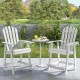 Two white HDPE patio chairs with armrests and footrests, placed beside a small table, ideal for outdoor relaxation.