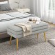 Grey velvet upholstered storage bench with removable top and gold metal legs, ideal for bedroom or living room use.