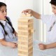 Children playing with a 54-piece tumbling timber toy made of natural pine wood, promoting coordination and imagination.