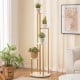 Five-tier indoor metal plant stand with a golden frame and white shelves, perfect for corner plant display.