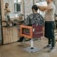 Hydraulic barber chair with 360-degree swivel, red leather, and adjustable headrest for hair styling comfort.