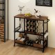 Rustic brown 3-tier bar cart on wheels with glass racks, holding wine bottles and glasses, ideal for home bar use.