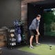 Golf bag organizer for 2 bags with club rack, featuring lockable wheels and sturdy metal frame for indoor/outdoor use.