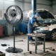 High-velocity 20-inch pedestal fan in black with adjustable height, ideal for cooling large areas in workshops.