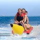 Three kids riding a bright yellow inflatable banana boat, featuring non-slip seats and durable PVC construction.