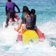 Three-person inflatable banana boat in bright red and yellow, featuring durable PVC construction and comfortable EVA.
