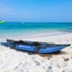Inflatable 2-person kayak in blue on the beach, featuring durable aluminium oars and comfortable adjustable seats.