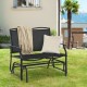 Black iron patio rocking chair with a cozy blanket and pillow, perfect for leisurely afternoons in the backyard.