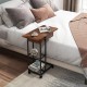 C-shaped end side table in rustic brown with charging station, wheels, and open storage for easy access beside the bed.