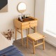 Bamboo makeup vanity table with movable mirror, two storage drawers, and tempered glass top for compact spaces.
