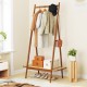 Bamboo clothes rack with a spacious rattan shelf and copper hooks, providing versatile storage for clothes and.
