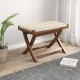 Folding natural rattan ottoman with hand-woven seat, crafted from teak wood, perfect for small spaces and comfort.