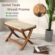 Folding natural rattan ottoman with hand-woven seat, solid teak wood frame, ideal for space-saving seating.