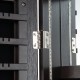 Close-up of the hinge on the 47-inch brown lockable jewelry cabinet armoire with LED lights and velvet lining.