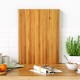 Extra large 24" teak wood cutting board with handles, featuring a reversible design for versatile kitchen use.