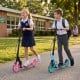 Kids riding the blue foldable kick scooter with large light-up wheels, perfect for ages 8 and up, on a school path.
