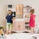 Kids kitchen playset in pink featuring a microwave, coffee maker, and sink, perfect for imaginative cooking play.