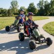 Kids pedal go-kart in green with steering wheel and gear shifter, perfect for outdoor fun on various surfaces.