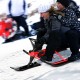Kids snow sled in red with steering wheel and double brakes, designed for stability and comfort during winter fun.
