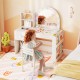 Child sitting at the kids vanity table with lighted mirror, surrounded by toys and colorful decor for imaginative play.