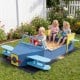 Large blue wooden kids sandbox shaped like an airplane, featuring a spacious seat and colorful propeller for.