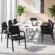 Set of four black leather office reception chairs with padded armrests, ergonomic backrests, and heavy-duty metal.