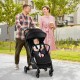 Lightweight baby stroller being used by a parent and child outdoors, showcasing its compact design for travel.