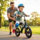 Toddler riding a lightweight black balance bike with adjustable seat and anti-skid tires, enjoying outdoor fun.