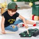 Child playing with the green electronic drum set, featuring built-in stereo speakers and various sound options for fun.