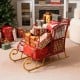 Red metal Christmas Santa sleigh basket with gold base, filled with gifts, perfect for festive storage and decoration.