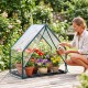 Mini greenhouse with metal frame, waterproof bottom mat, and vibrant flowers, ideal for garden or balcony use.