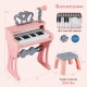 Mini keyboard piano for kids in pink with 25 keys, microphone, and matching stool for music play and learning.