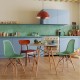 Modern 3-piece dining set featuring a round MDF table and two green hollow plastic chairs, perfect for small spaces.