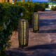 Two solar-powered square wicker floor lamps with warm yellow light, perfect for outdoor patios and gardens.